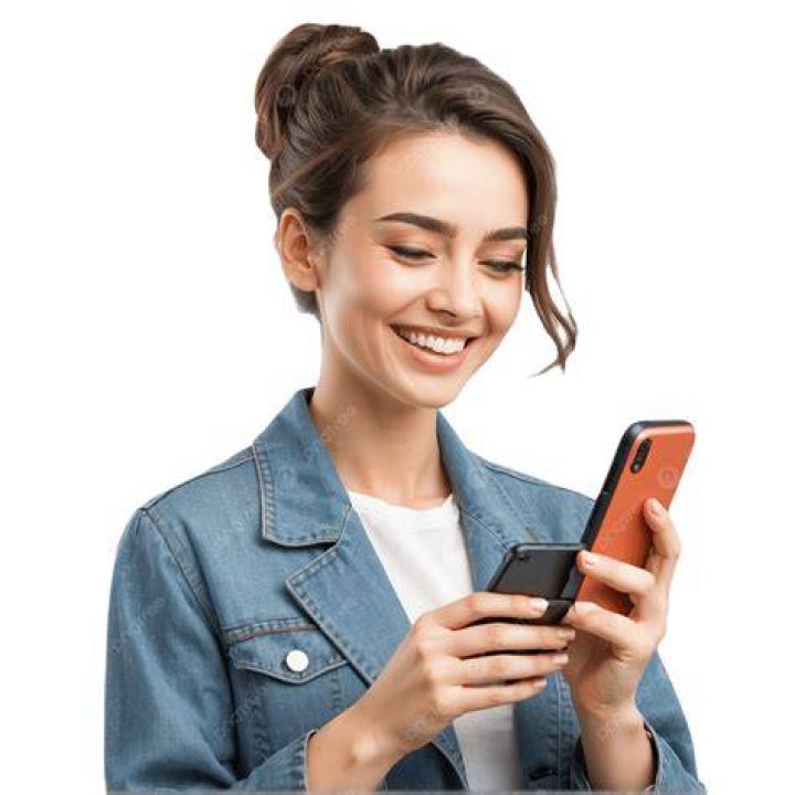 a woman is holding an object in her hand and smiling at the camera